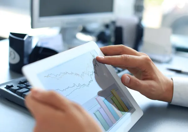 Geschäftsmann analysiert Finanzstatistiken auf dem Tablet-Bildschirm — Stockfoto