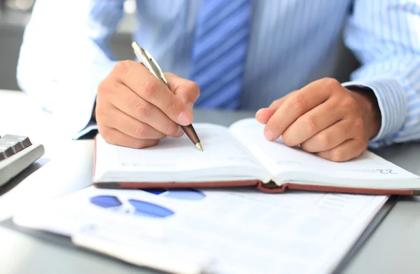 Businessman makes a note in notebook — Stock Photo, Image