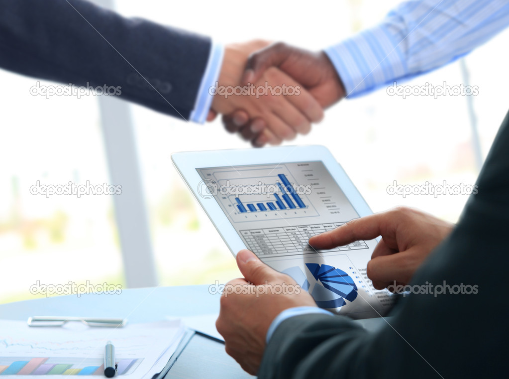 Business associates shaking hands in office