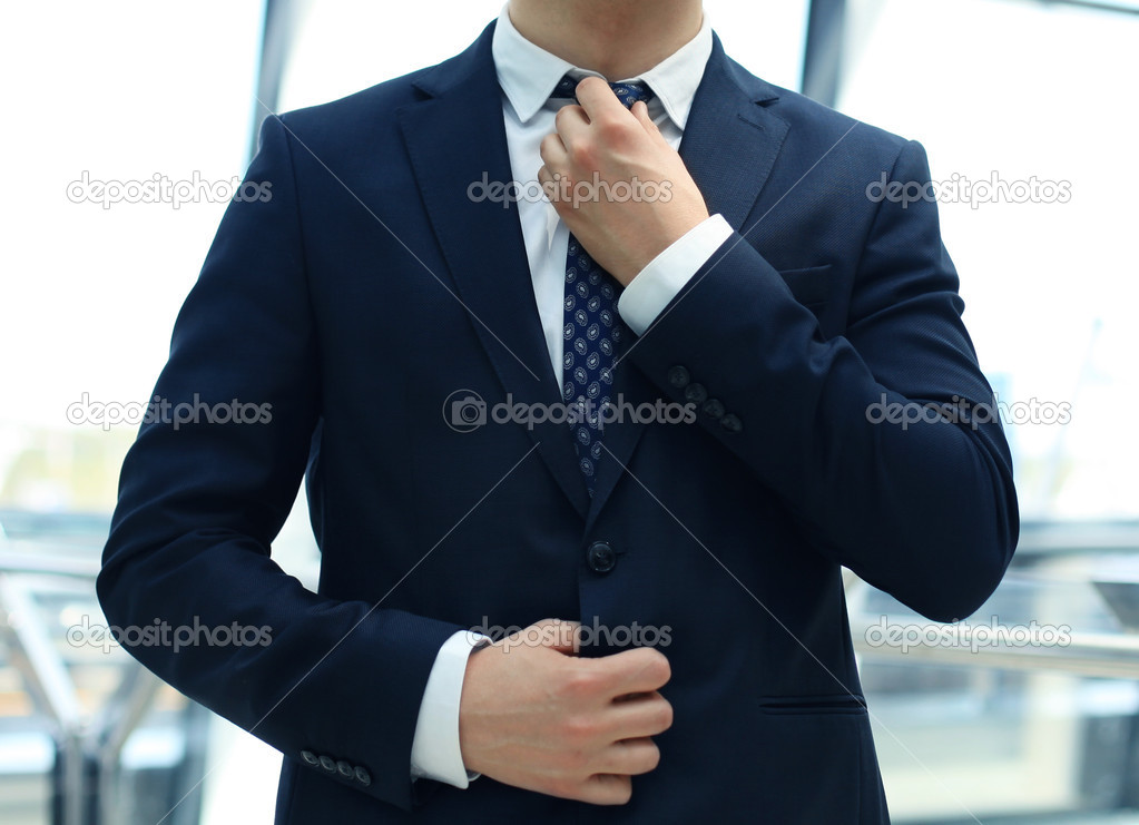 businessman adjusts his tie