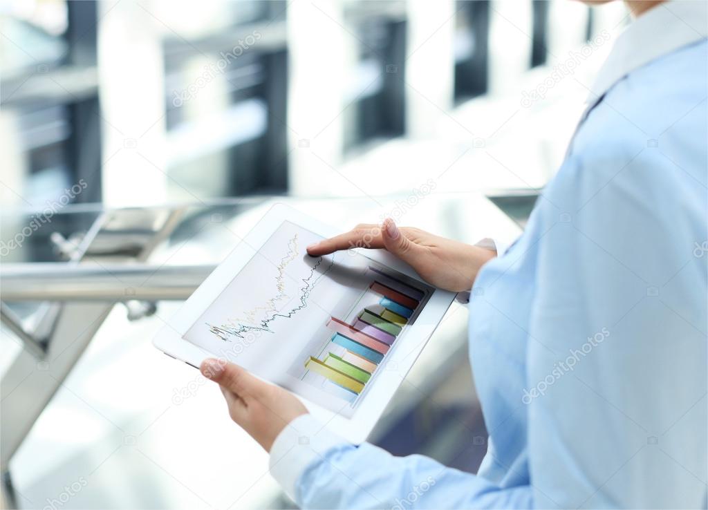 Business person analyzing financial statistics displayed on the tablet
