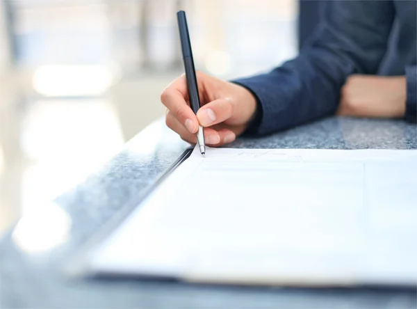 Businesswoman sitting at office desk signing a contract with shallow focus on signature — Stock Photo, Image