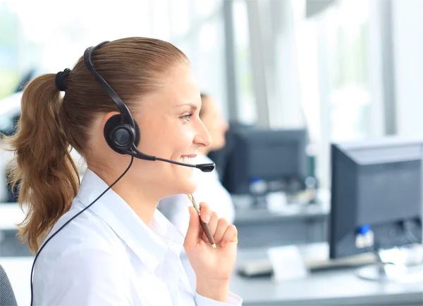 Jovem operadora de call center bonita com fone de ouvido no escritório — Fotografia de Stock