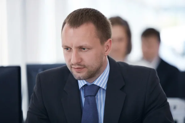 Portrait of happy business man with his colleagues in background — Stock Photo, Image