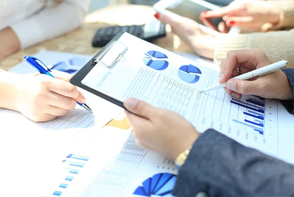 Unrecognizable business person analyzing graphs and taking notes — Stock Photo, Image