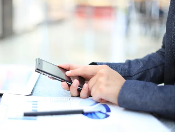 Primer plano de una mujer de negocios que usa un teléfono inteligente móvil — Foto de Stock