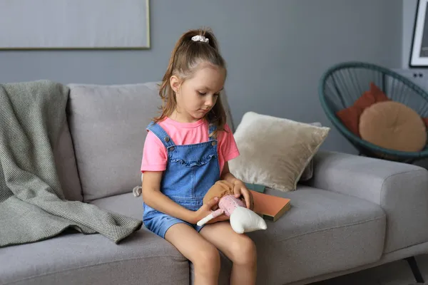 在家里客厅里 兴奋的孩子坐在沙发上玩毛绒玩具 — 图库照片