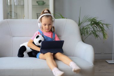 Mesafe öğrenme. Çevrimiçi e-öğrenme sisteminde çalışırken dizüstü bilgisayar kullanan neşeli küçük kız