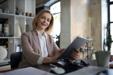 İşyerindeki güzel iş kadını dijital tablet kullanıyor.