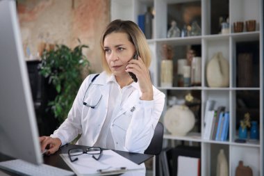 Konsültasyon gören orta yaşlı kadın doktor.