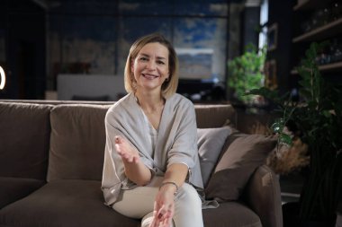 Gülümseyen orta yaşlı güzel bir kadının portresi. Kameraya bakıyor, video görüşmesi yapıyor, iş görüşmesi yapıyor ya da internetten biriyle çıkıyor..