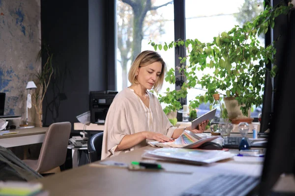 İşyerindeki güzel iş kadını dijital tablet kullanıyor..