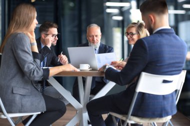 Bir grup iş ortağı ofiste fikir ve planlama işini tartışıyor.