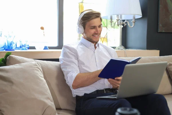 Συγκεντρωμένος Νεαρός Ελεύθερος Επαγγελματίας Επιχειρηματίας Κάθεται Στον Καναπέ Φορητό Υπολογιστή — Φωτογραφία Αρχείου