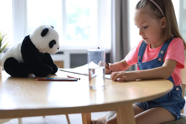 Uśmiechnięta Szczęśliwa Dziewczyna Siedzi Stole Zabawką Misia Panda Blisko Jej — Zdjęcie stockowe