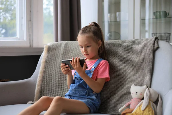 Smiling Little Girl Sitting Sofa Playing Online Games Web Surfing — стоковое фото