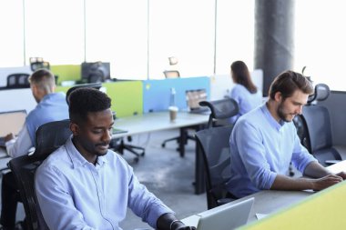 Ofiste çalışırken borsa verilerini analiz eden modern iş adamları