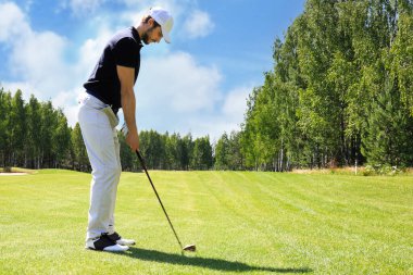 Güneşli bir günde golf oynayan golf oyuncusu tam uzunlukta. Profesyonel erkek golfçü golf sahasında çekim alarak
