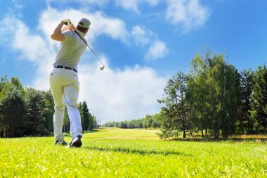 Golfçü yaz tatilinde golf sahasında golf sahasını vuruyor.