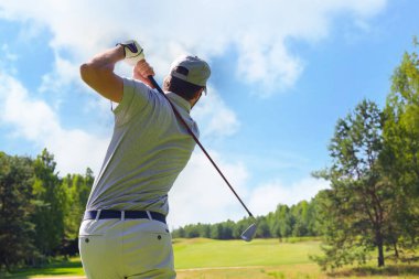 Golfçü yaz tatilinde golf sahasında golf sahasını vuruyor.