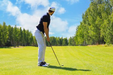 Güneşli bir günde golf oynayan golf oyuncusu tam uzunlukta. Profesyonel erkek golfçü golf sahasında çekim alarak
