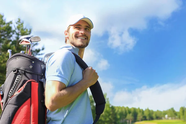 男子高尔夫球手走过高尔夫球杆绿草时提着高尔夫球袋的画像 — 图库照片