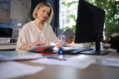 İşyerindeki güzel iş kadını dijital tablet kullanıyor..