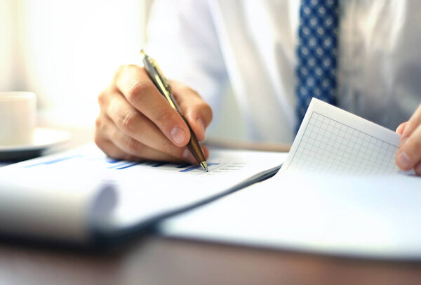 Бизнесмен ведет деловые записи в офисе
