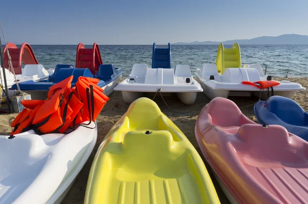 Plastic boats in different colours, on the seashore — Stock Photo, Image