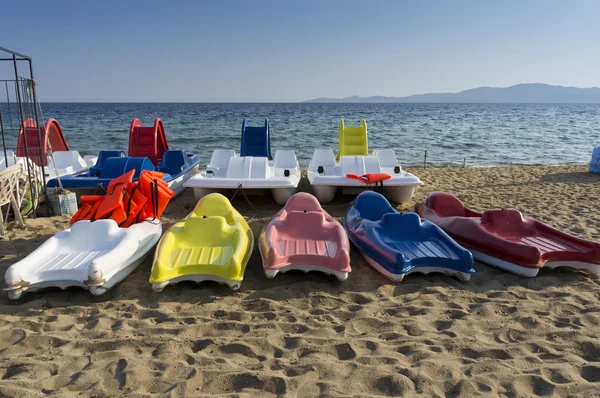 Plastic boats in different colours, on the seashore — Stock Photo, Image