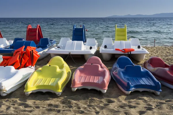 Plastic boats in different colours, on the seashore — Stock Photo, Image