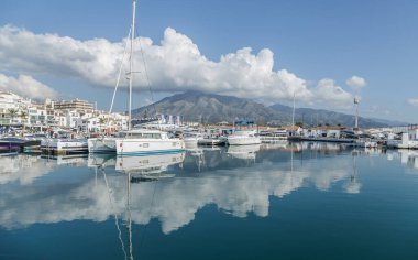 Bir deniz limanının yansıması. Arkasında dağ olan bir deniz limanı kerhanesi.
