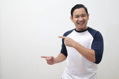 Reklam konsepti, mutlu Asyalı adam gülümseyen ve onu işaret eden, terfi için boş alan