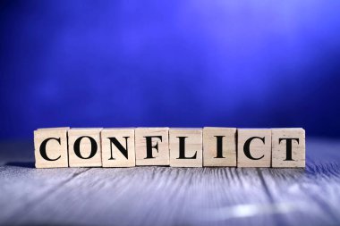 Çakışma, metin kelimeleri tipografisi koyu mavi arkaplan üzerine ahşap harfle yazılmış, hayat ve iş motivasyonu ilham verici kavram