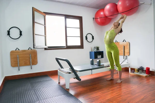 Woman doing stretching exercises before a pilates routine — Stock Photo, Image