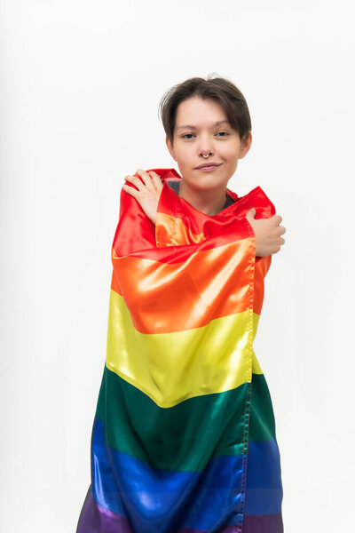 young girl involved in an lgbti icon flag looking at camera confident in front of a white background
