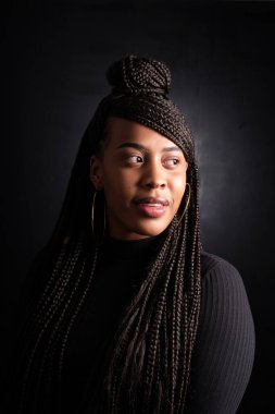 studio beauty portrait of a young black woman looking to her left side in a concept styte. High quality photo