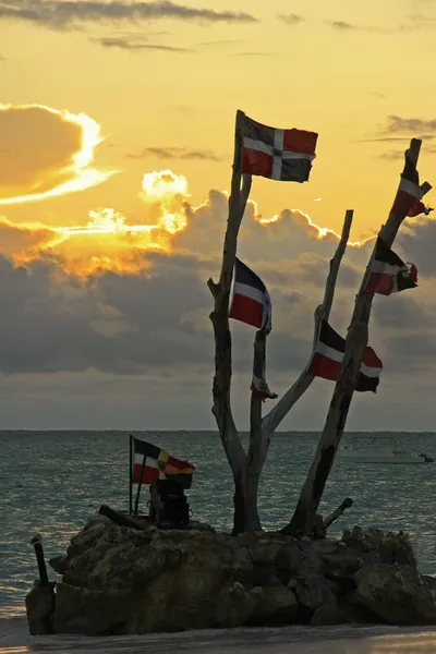 Dominicaanse vlaggen bij zonsopgang op bavaro beach, Dominicaanse Republiek — Stockfoto