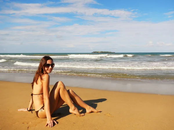 Ung kvinna sitter på en strand, playa el limon, Dominikanska republ — Stockfoto