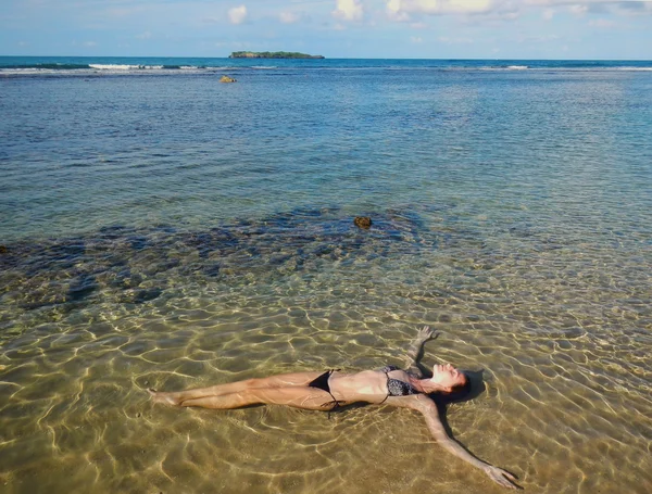 Jonge vrouw drijvend in ondiepe water — Stockfoto