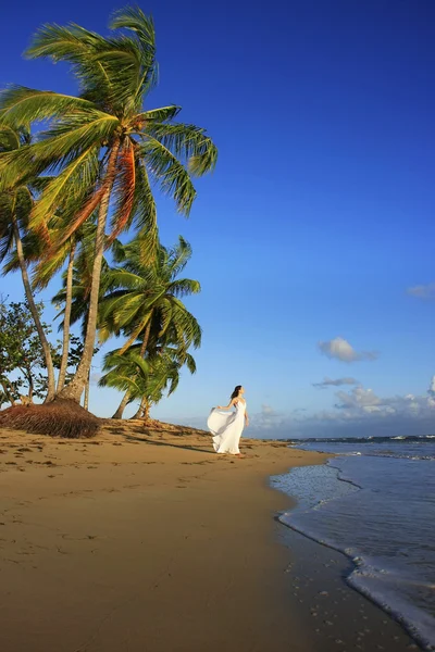 Jeune femme en robe blanche sur une plage — Photo