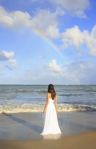 Ung kvinna i vit klänning på en strand — Stockfoto