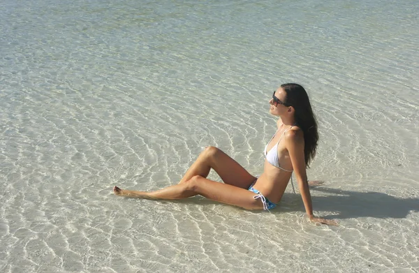 Bikini net sığ sularda oturan genç kadın — Stok fotoğraf