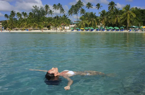 Jonge vrouw in bikini drijvend in helder water — Stockfoto