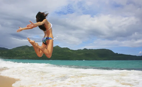 Ung kvinna i bikini hoppning på rincon beach — Stockfoto