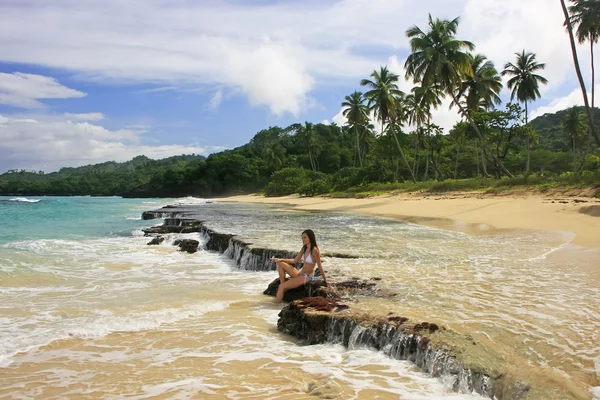 Jeune femme en bikini assise sur des rochers à la plage de Rincon, Samana p — Photo