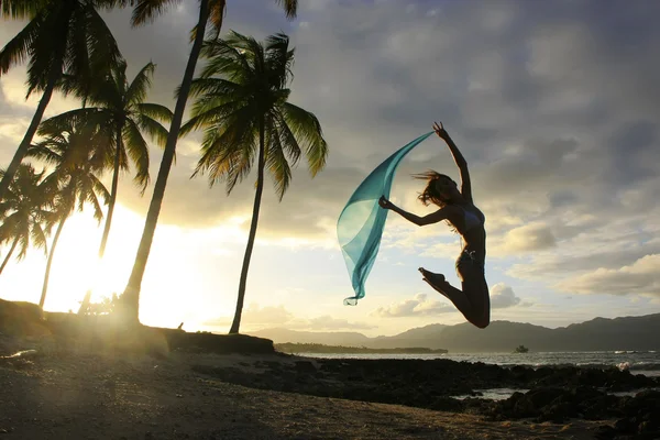 Silhuett av ung kvinna hoppa på stranden las galeras — Stockfoto