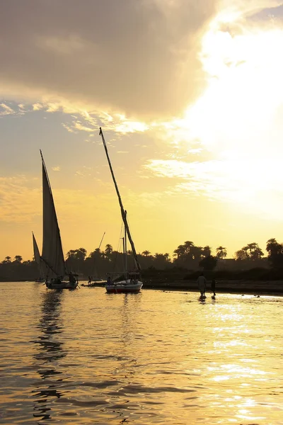 日落时分，卢克索尼罗河河上航行的桅船 — 图库照片