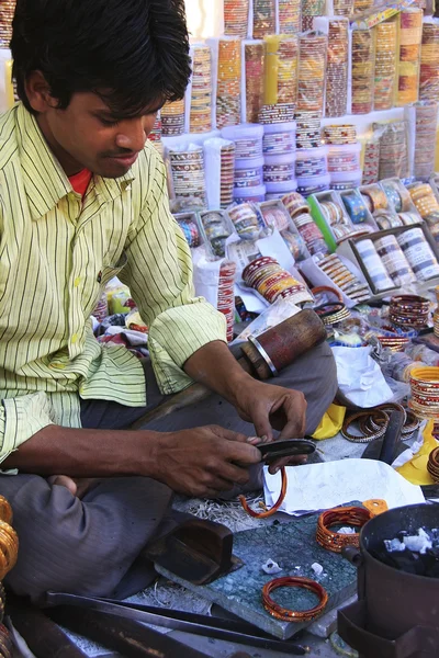 Jeune homme fixant des bracelets colorés au marché, Bundi, Rajast — Photo