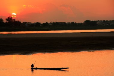 Silhouetted boat on Mekong river at sunset, Vientiane, Laos clipart
